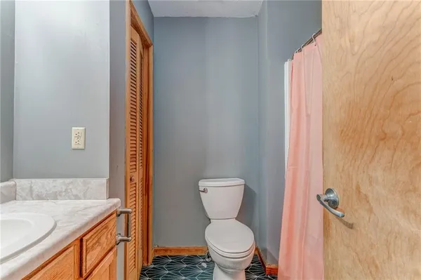 a bathroom with a granite countertop toilet and a sink