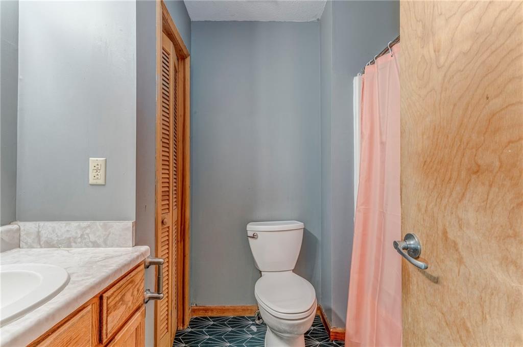 519 East Valley Road Northeast Rydal, GA 30171 - Photo 19 of 28 a bathroom with a granite countertop toilet and a sink