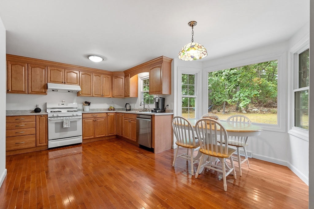 170 Mill Road, Unit 170 Chelmsford, MA 01824 - Photo 8 of 42 a kitchen with a table chairs sink and cabinets