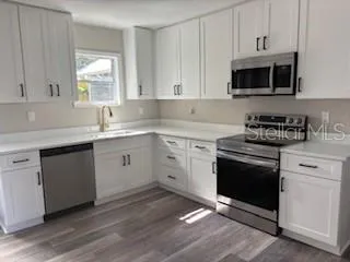 a kitchen with stainless steel appliances granite countertop a sink a stove a microwave and cabinets