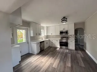 a kitchen with a white cabinets and wooden floor