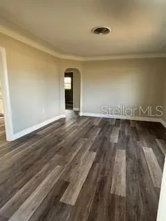 an empty room with wooden floor and a window
