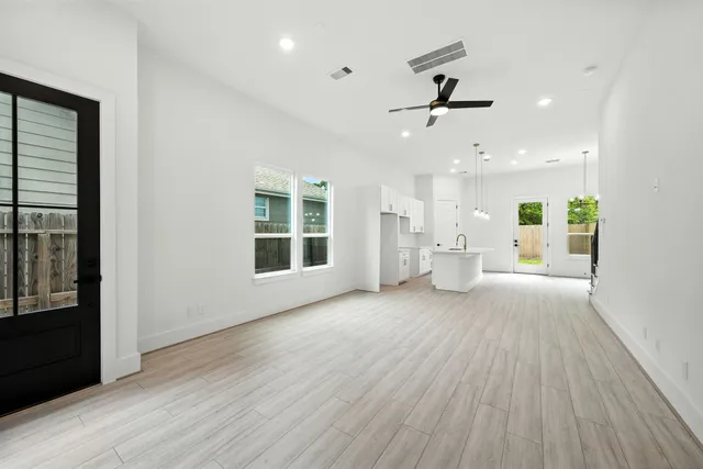 a view of an empty room with a window and wooden floor