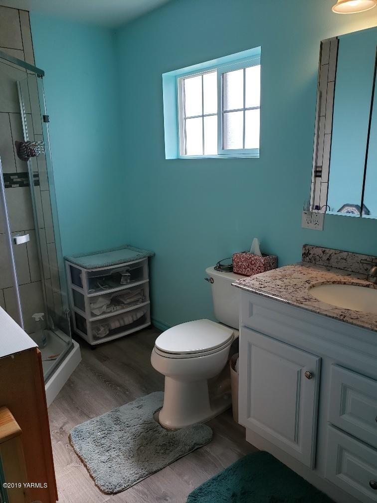 6235 Lateral A Road Wapato, WA 98951 - Photo 29 of 30 a bathroom with a granite countertop toilet a sink and a mirror
