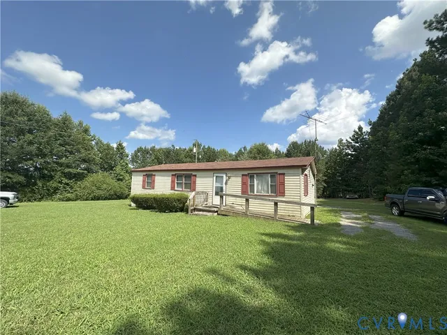 a view of a house with a big yard and a large tree