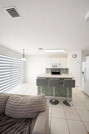 a kitchen with a table chairs and a refrigerator