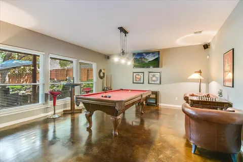 a room with furniture pool table and a large window