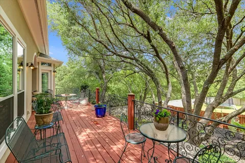 a view of a patio with table and chairs potted plants and large tree