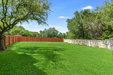 a view of yard with green space and wooden fence
