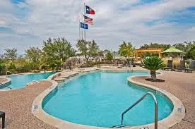 a view of a swimming pool with a yard and plants