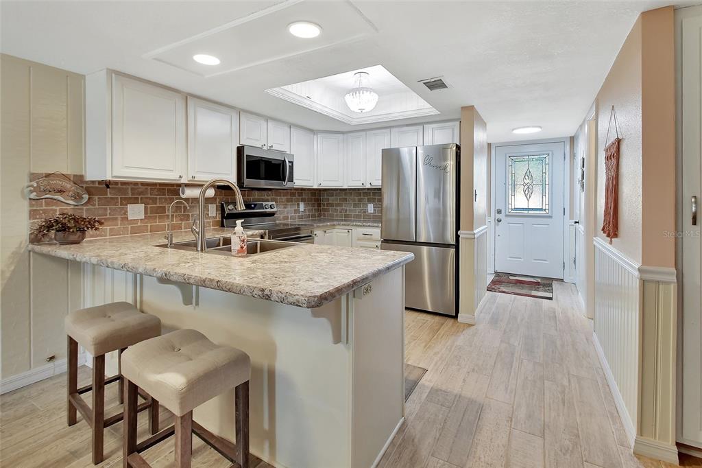 2329 River Ridge Road, Unit 4 DeLand, FL 32720 - Photo 6 of 23 a kitchen with stainless steel appliances granite countertop a refrigerator and a stove top oven