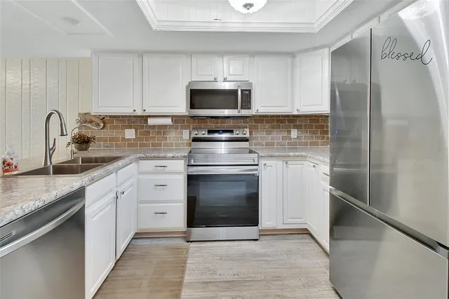 a kitchen with stainless steel appliances granite countertop a stove a sink and a refrigerator
