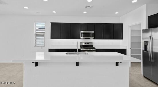 16340 South 182nd Drive Goodyear, AZ 85338 - Photo 27 of 38 a living room with stainless steel appliances kitchen island furniture and a flat screen tv