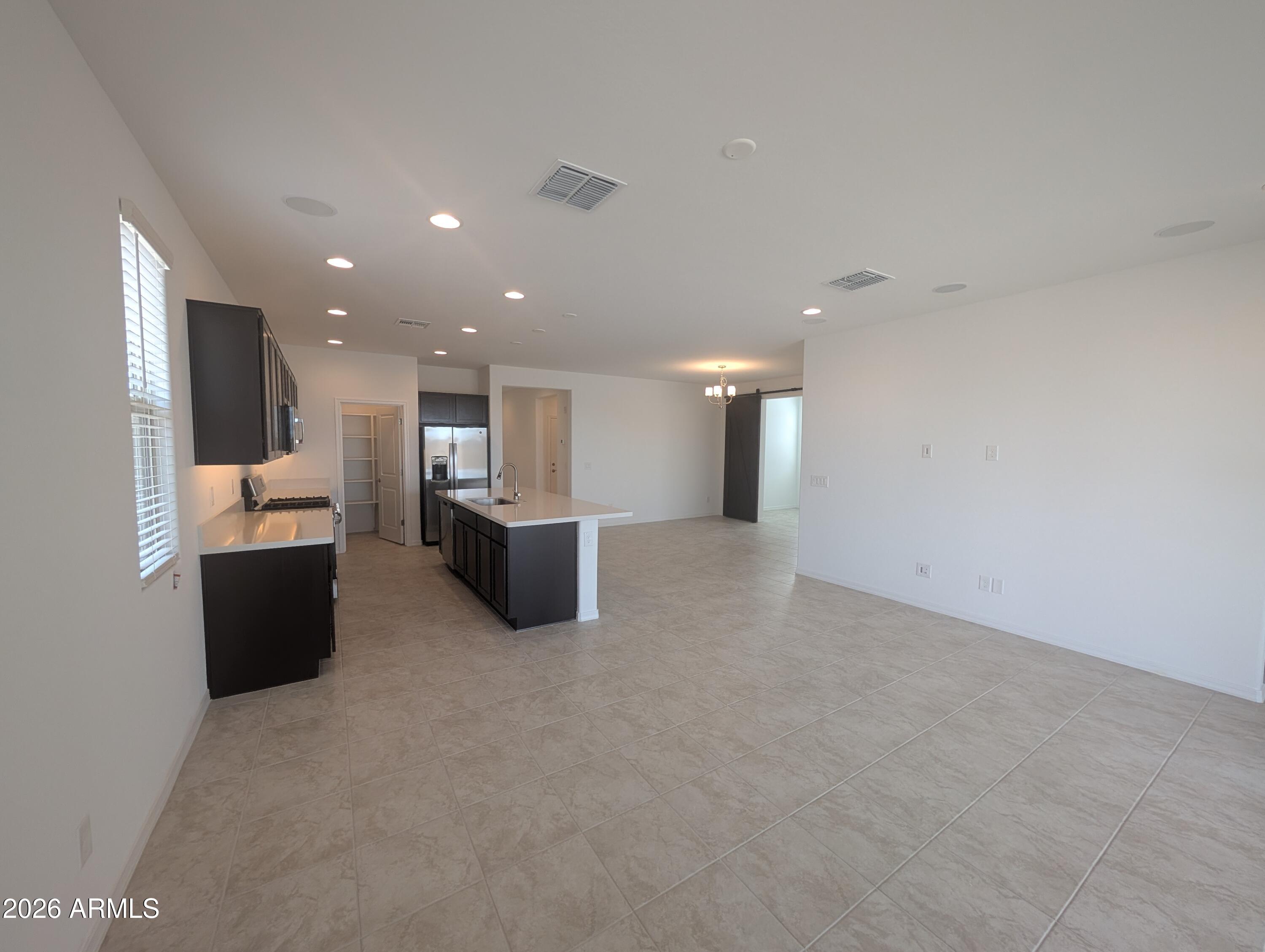 16340 South 182nd Drive Goodyear, AZ 85338 - Photo 6 of 38 a view of kitchen with stainless steel appliances kitchen island microwave and stove