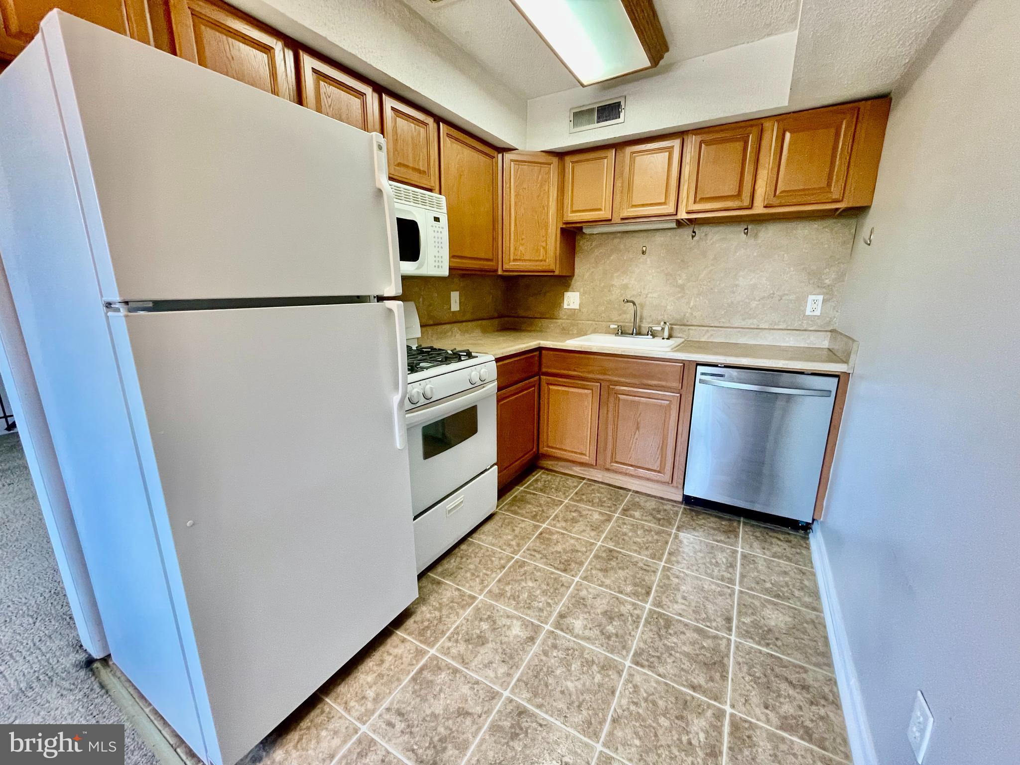 810 North Forklanding Road, Unit 116 Maple Shade, NJ 08052 - Photo 6 of 11 a kitchen with stainless steel appliances granite countertop a refrigerator a stove a sink and dishwasher