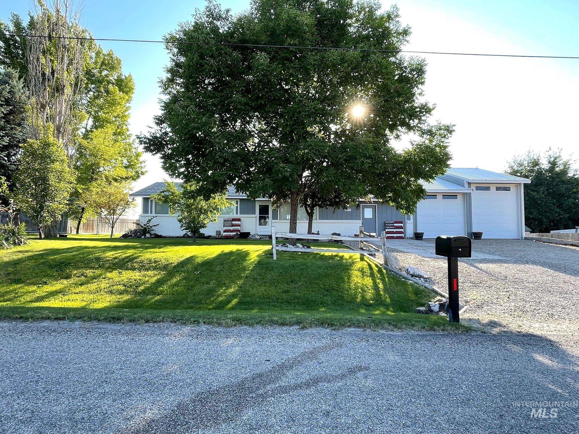12733 South Five Mile Road Kuna, ID 83634 - Photo 1 of 21 View of front facade with a front lawn, gravel driveway, and an attached garage