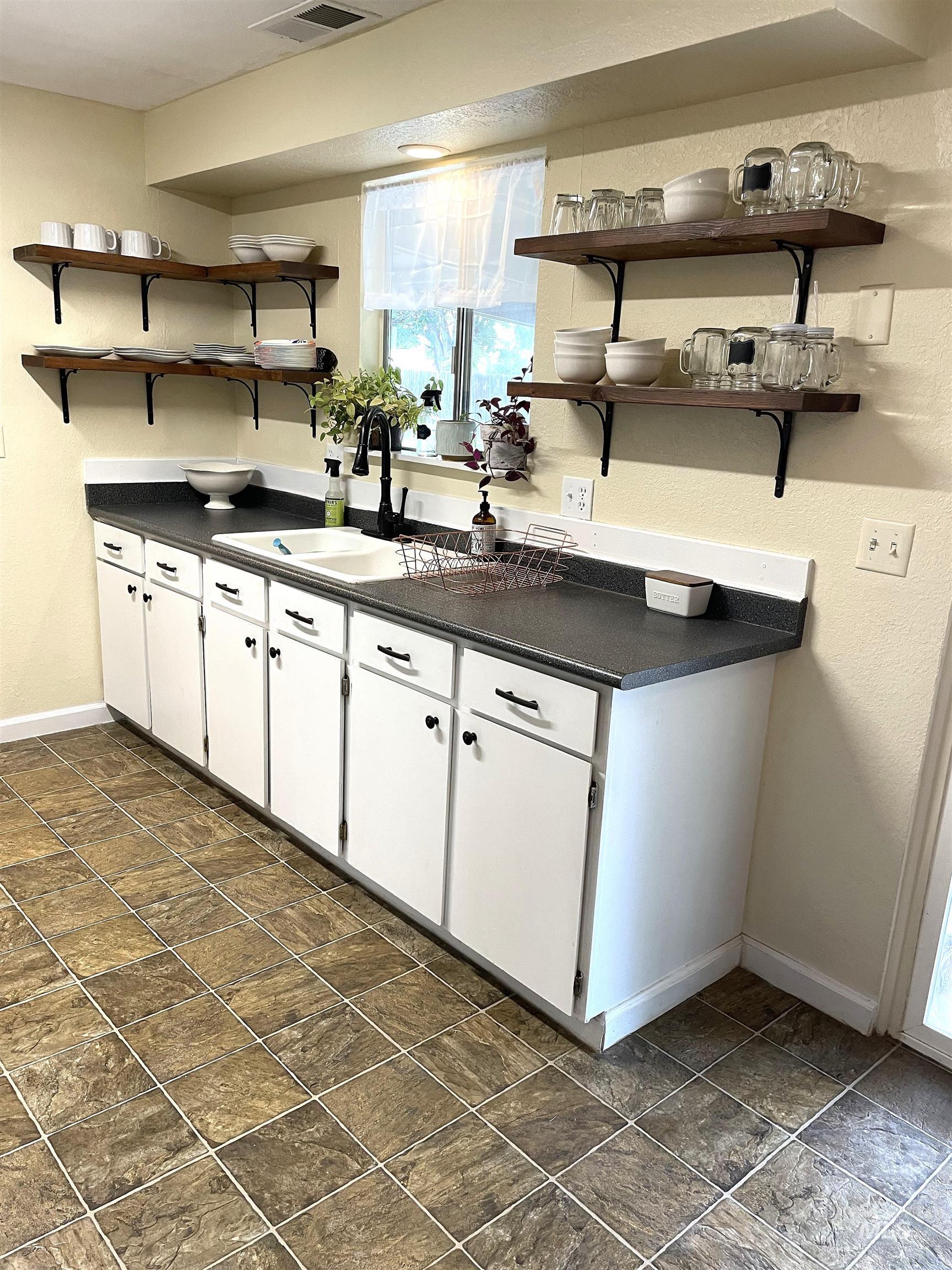 12733 South Five Mile Road Kuna, ID 83634 - Photo 6 of 21 Kitchen featuring open shelves, dark countertops, and white cabinets