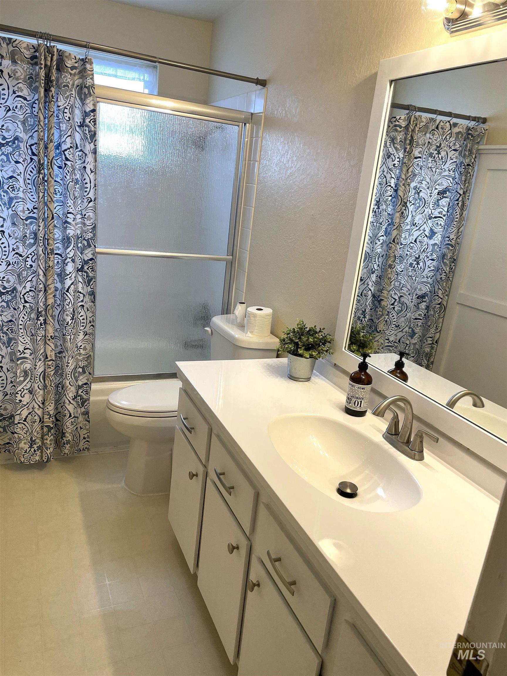 12733 South Five Mile Road Kuna, ID 83634 - Photo 10 of 21 Bathroom featuring a textured wall, shower / bath combo with shower curtain, and vanity