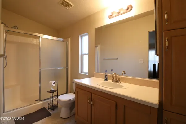 a bathroom with a sink a toilet a mirror and shower