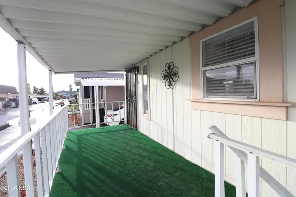 a view of a porch with furniture and a yard