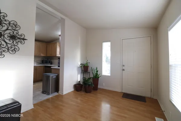 a view of a kitchen with fridge and wooden floor