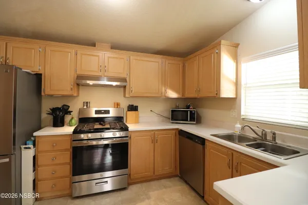 a kitchen with stainless steel appliances a stove a sink and cabinets