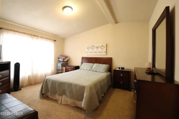 a bedroom with a bed and dresser with mirror