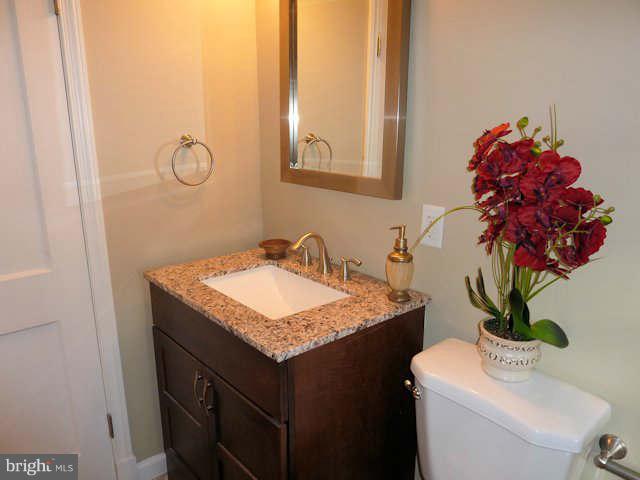 6521 Banbury Road Baltimore, MD 21239 - Photo 15 of 29 a bathroom with a granite countertop sink and a mirror