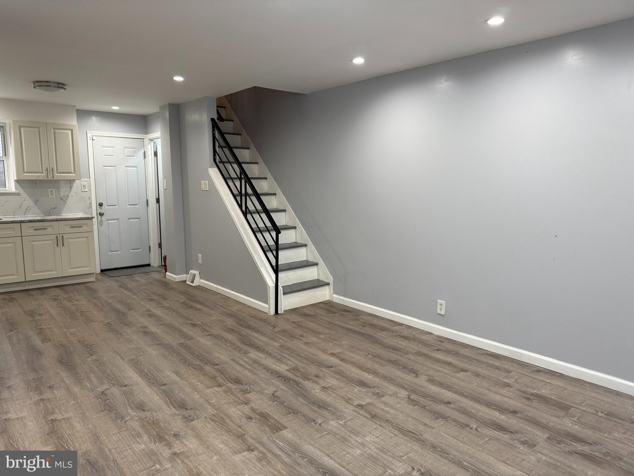 1326 South Colorado Street Philadelphia, PA 19146 - Photo 3 of 12 an empty room with wooden floor cabinet and windows