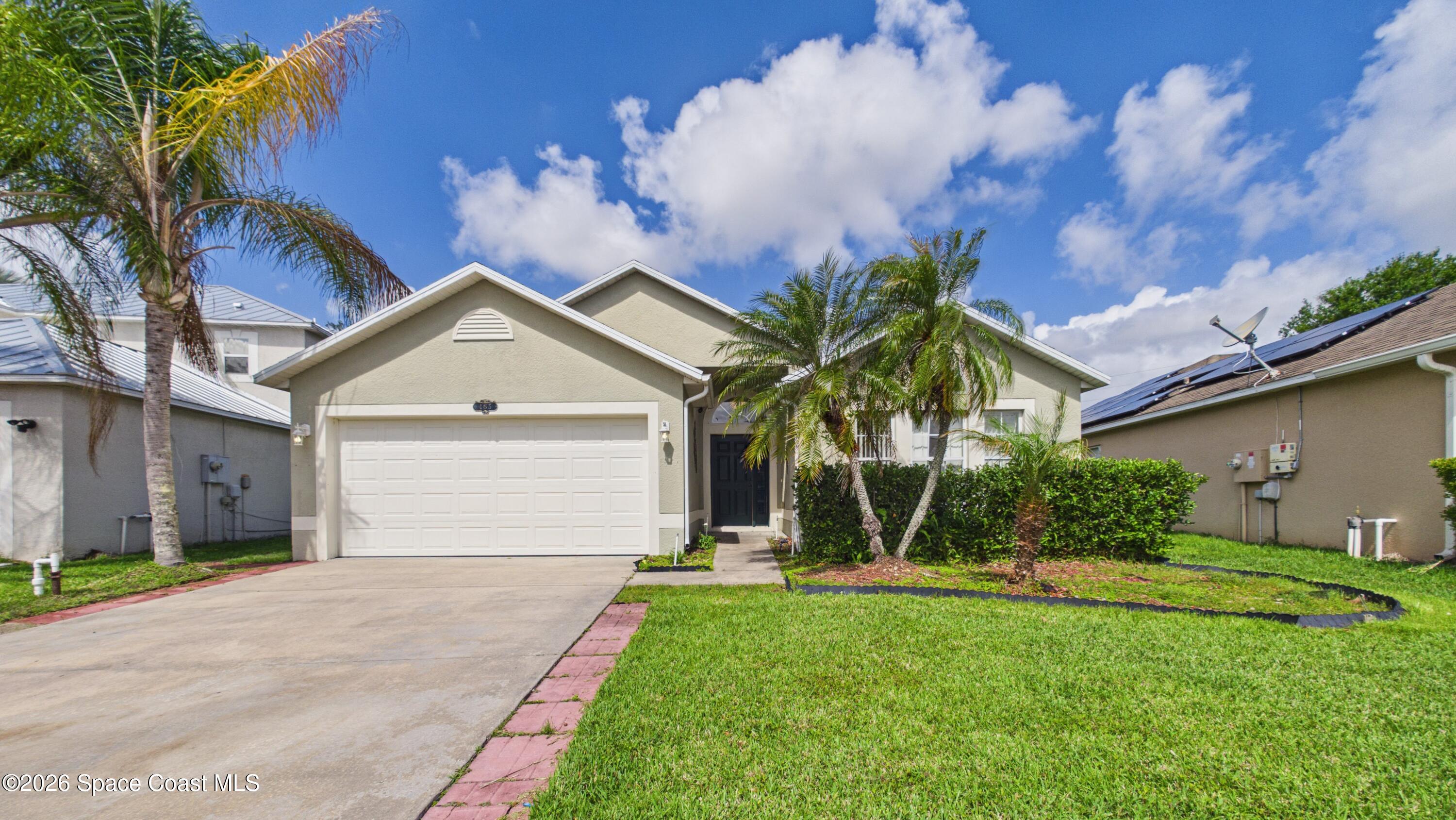 183 Stony Point Drive Sebastian, FL 32958 - Photo 2 of 27 a front view of a house with a yard and garage