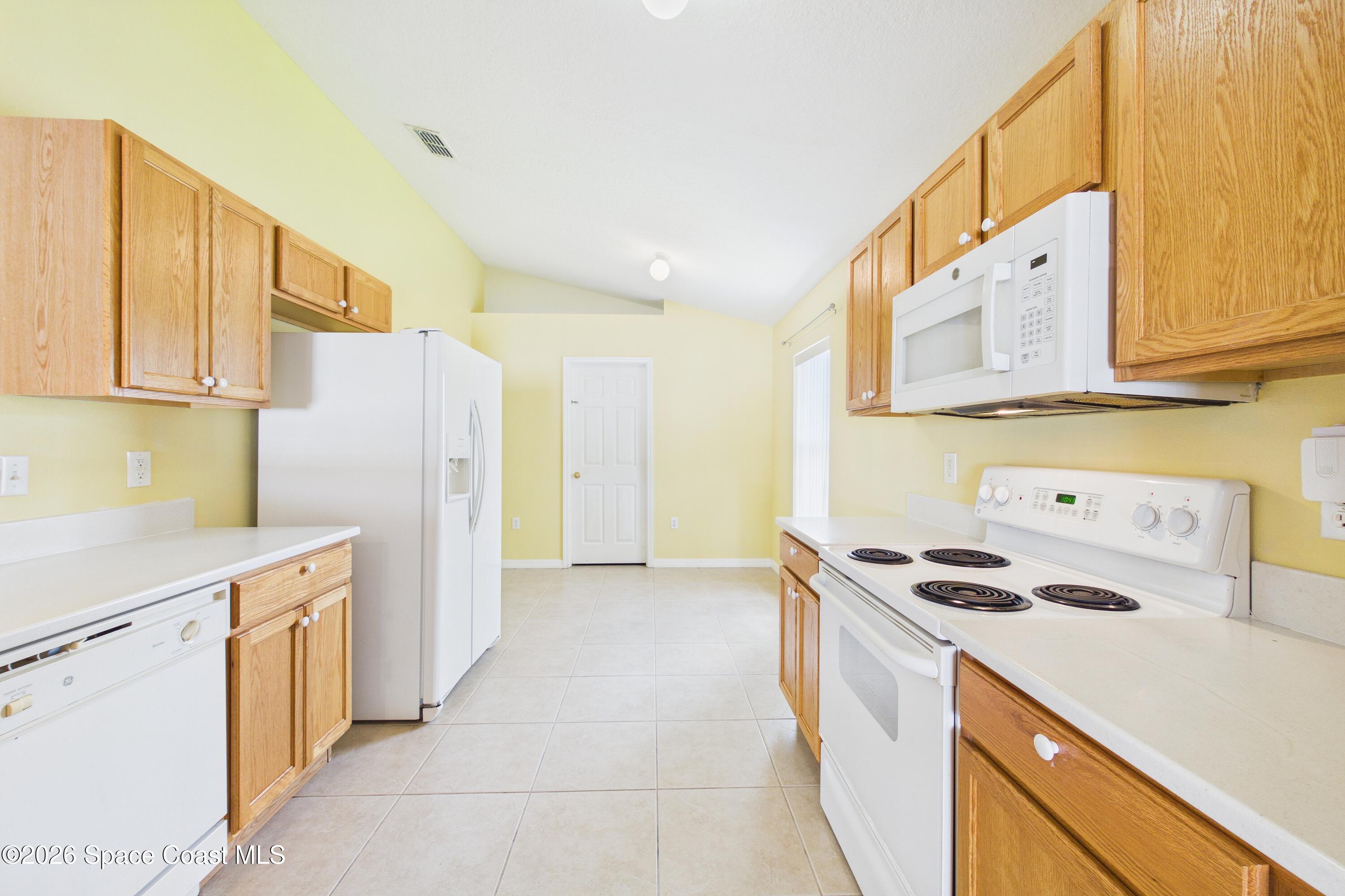 183 Stony Point Drive Sebastian, FL 32958 - Photo 7 of 27 a kitchen with a refrigerator a stove a sink and cabinets