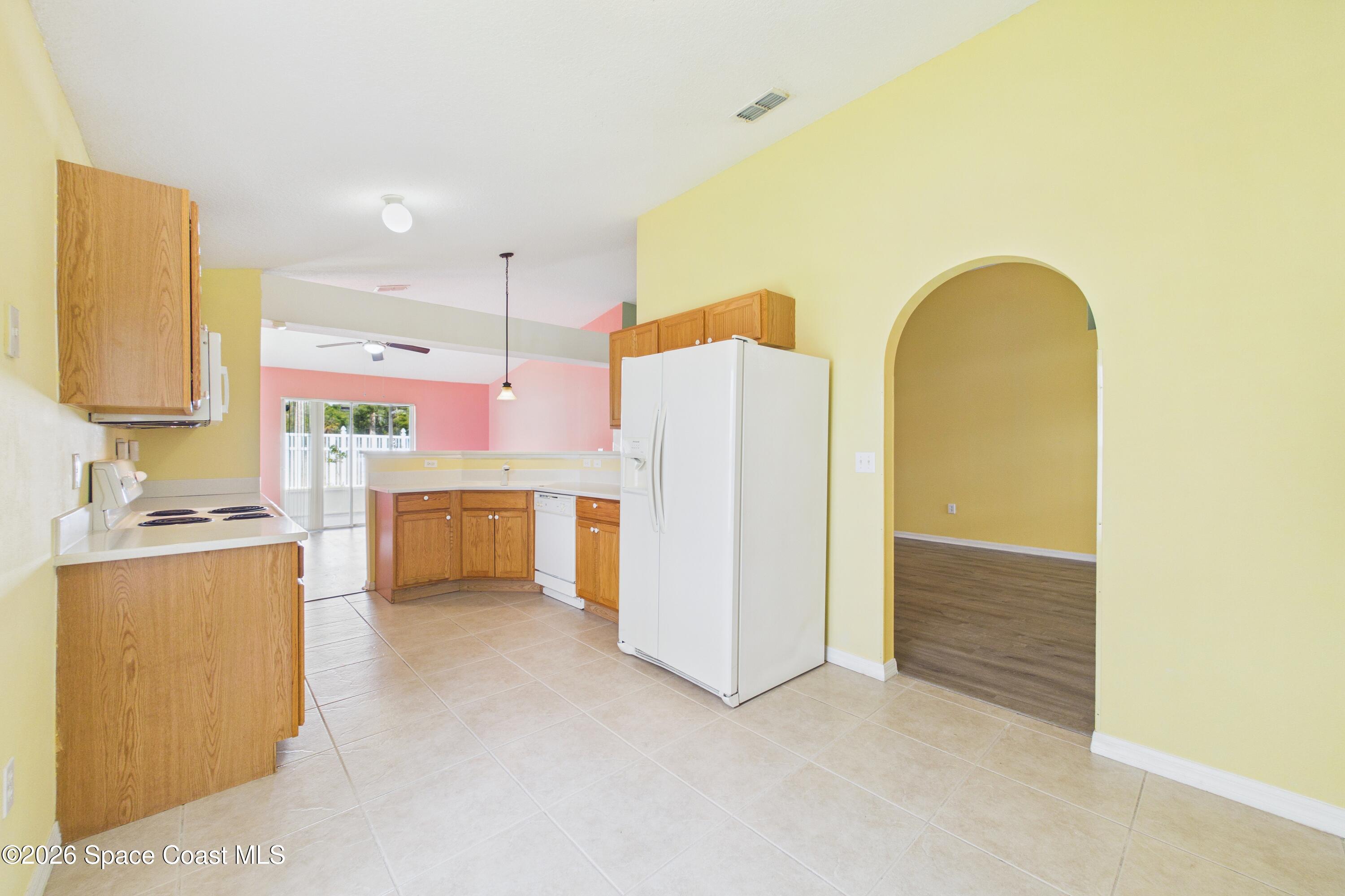 183 Stony Point Drive Sebastian, FL 32958 - Photo 8 of 27 a kitchen with refrigerator and white cabinets