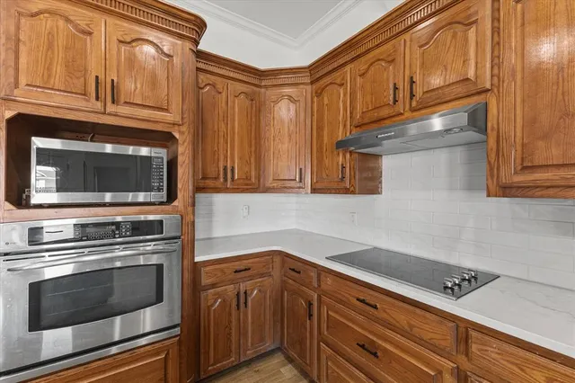 a kitchen with stainless steel appliances granite countertop a stove microwave and cabinets