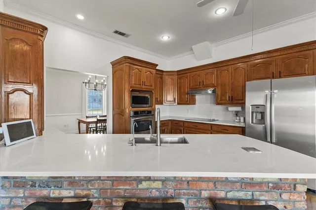 a kitchen with stainless steel appliances granite countertop a refrigerator and a stove