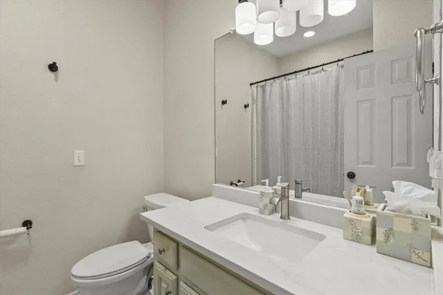 a bathroom with a sink vanity mirror and toilet