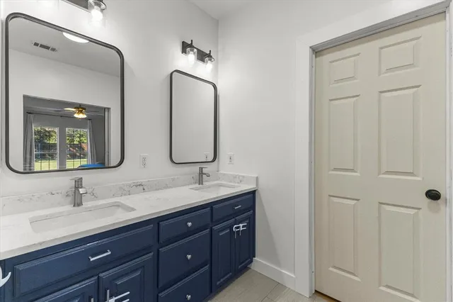 a bathroom with double vanity sinks and a mirror