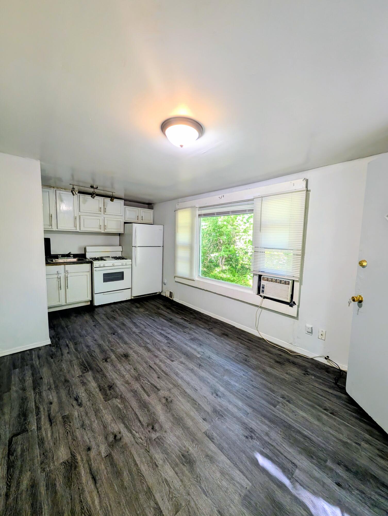 1910 South Calhoun Street Griffith, IN 46319 - Photo 2 of 19 an empty room with kitchen wooden floor and window