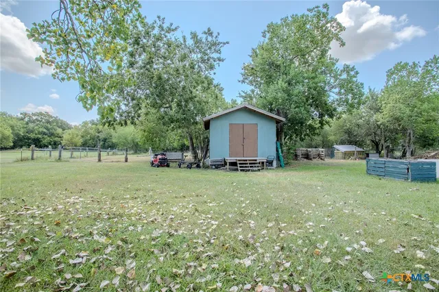 a view of a house with backyard and tree