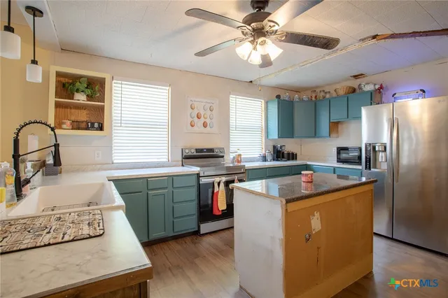 a kitchen with cabinets a sink appliances and a window