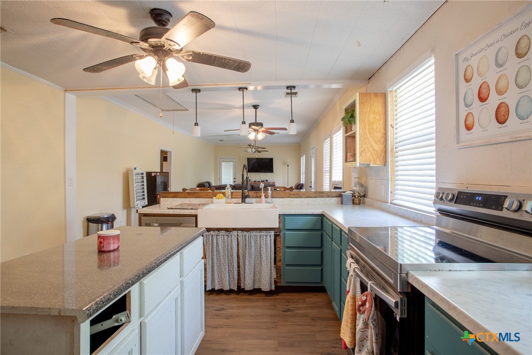 705 West Ash Street Edna, TX 77957 - Photo 4 of 19 a kitchen with stainless steel appliances granite countertop a sink a stove and a refrigerator