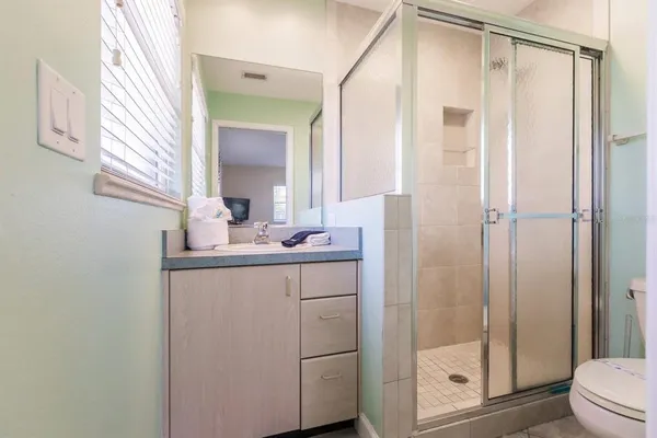a bathroom with a shower a sink and mirror