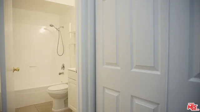 a bathroom with a granite countertop toilet and a shower