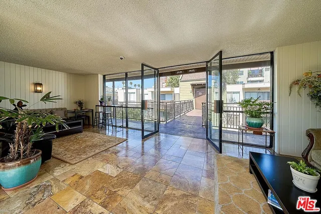 a living room with furniture a flat screen tv and a floor to ceiling window