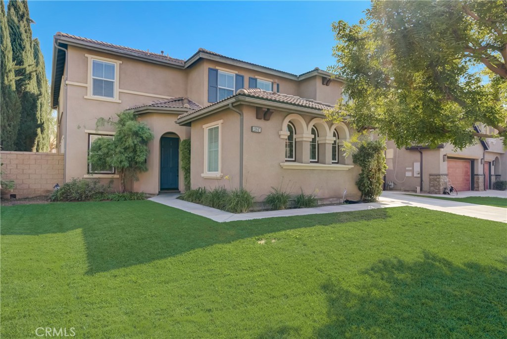a front view of a house with a yard and trees