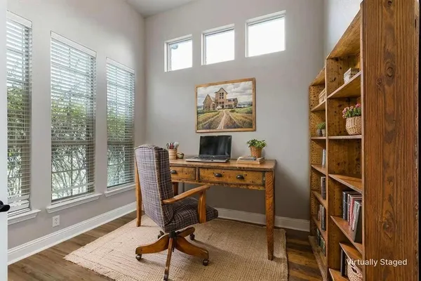 a view of a workspace with furniture and a window