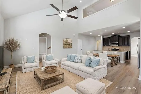 a living room with furniture kitchen view and a potted plant