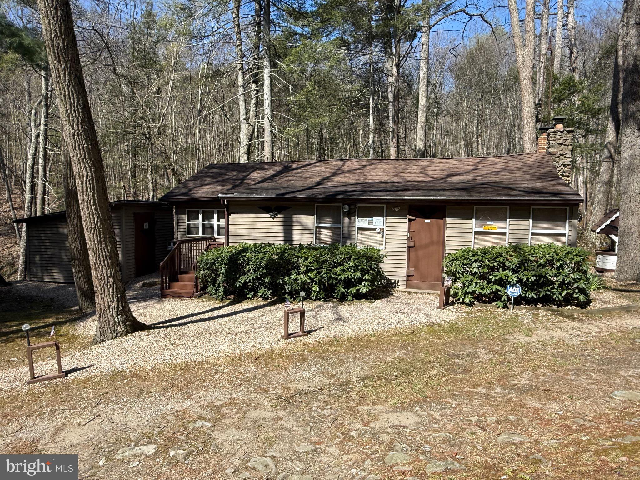a front view of a house with a garden and trees