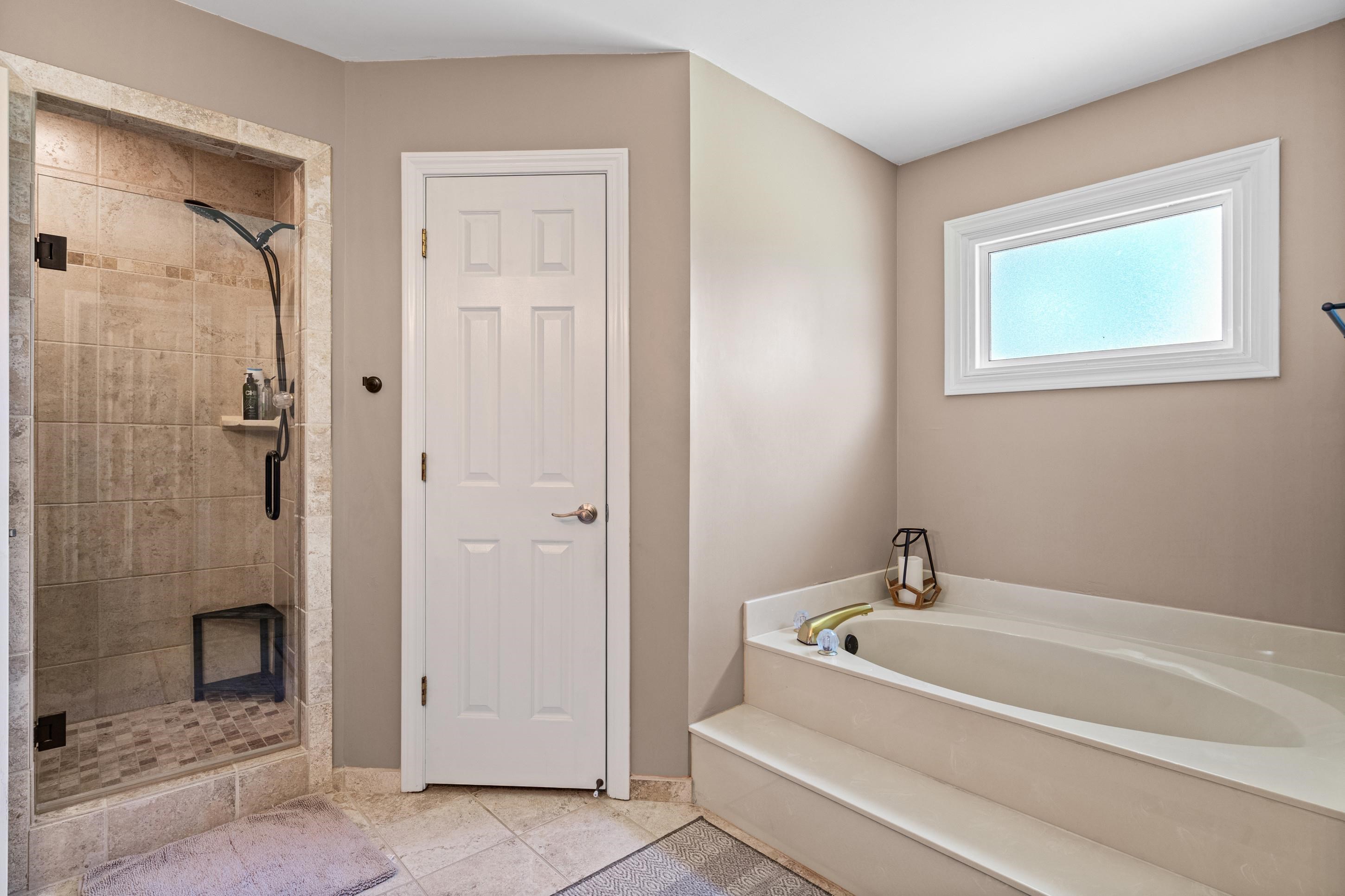 304 Spring Mill Road Collierville, TN 38017 - Photo 17 of 32 Tiled walk-in shower with glass enclosure, built-in shelf, and contrasting floor tile