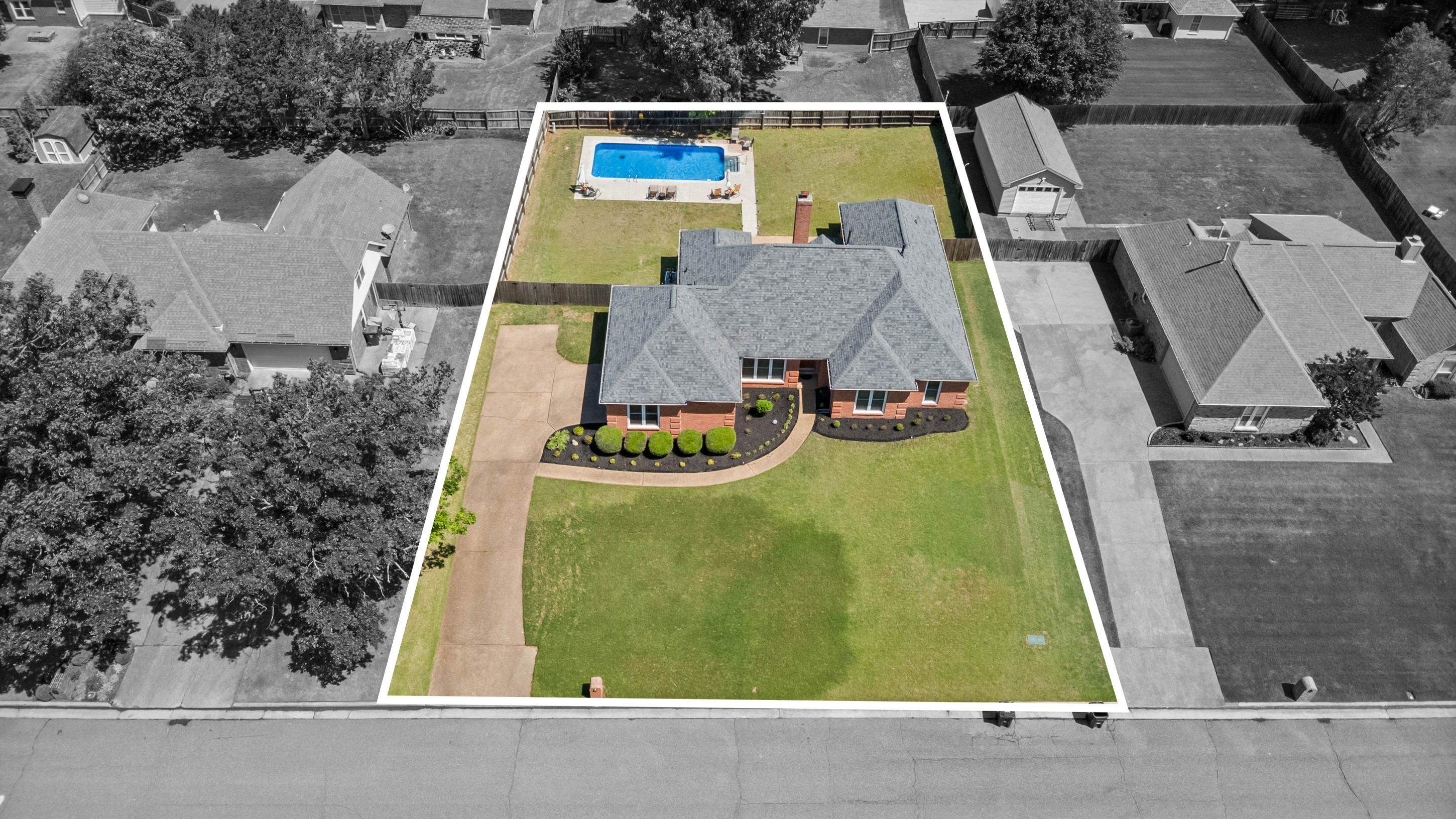 304 Spring Mill Road Collierville, TN 38017 - Photo 2 of 32 Brick residence featuring a shingled roof, a front lawn, an expansive paved driveway, and established front landscaping
