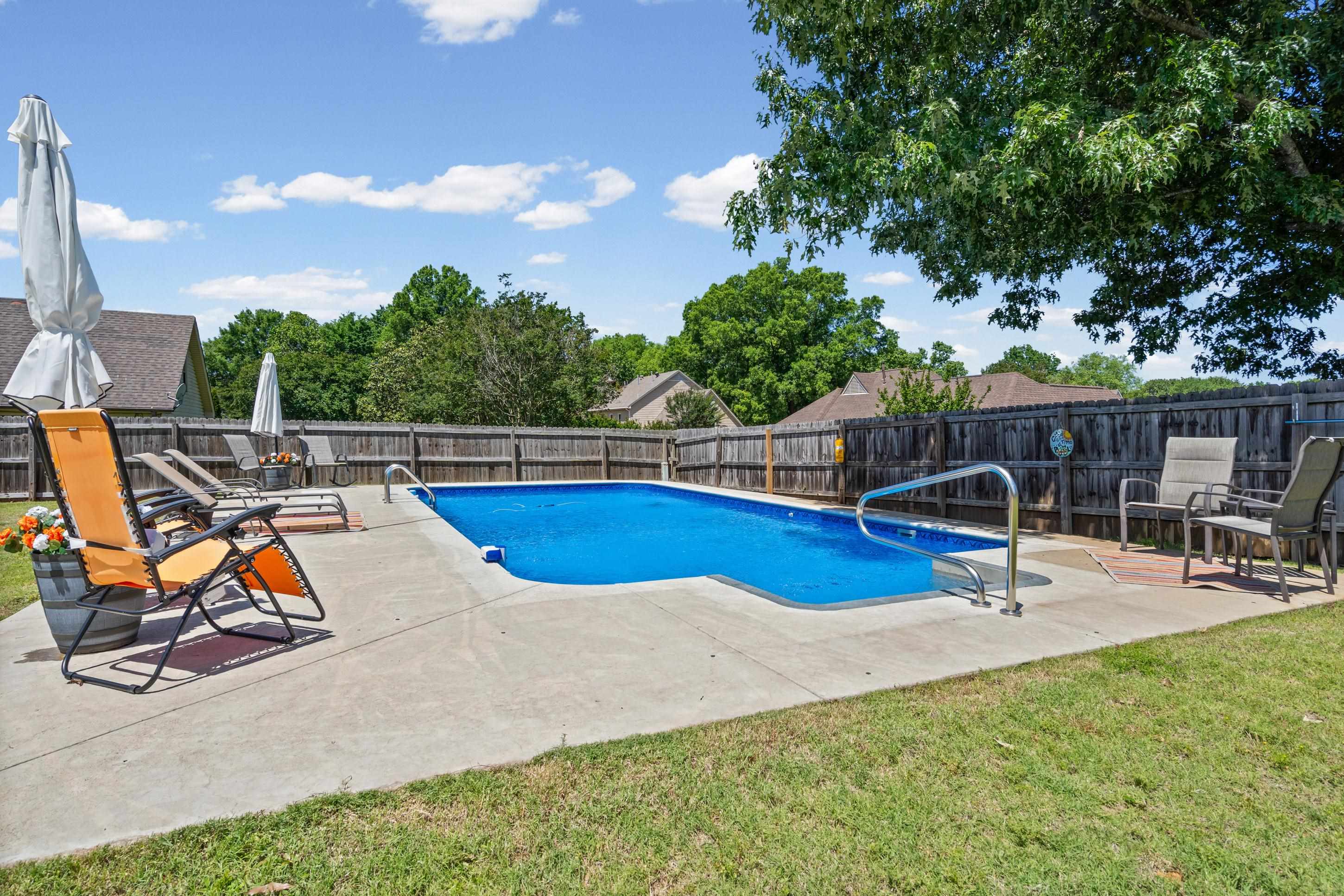 304 Spring Mill Road Collierville, TN 38017 - Photo 25 of 32 Fenced backyard featuring an in-ground swimming pool, concrete patio surround, and mature trees